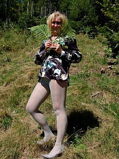 Horny housewife in light green pantyhose posing in the forest image 1